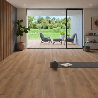 Versat Nogal 9x48 Wood Look Porcelain Tile featuring warm walnut-brown tones, installed in a modern living space with floor-to-ceiling glass doors and a garden-view terrace.