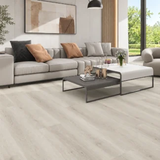 Latte SPC Vinyl Flooring featuring light beige wood-grain planks in a modern living room with a gray sofa, minimalist furniture, and natural lighting.